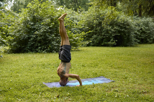 Tranquil figure executing headstand in lush park setting