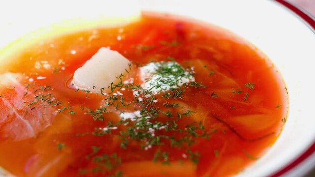 Panning right to left across a bowl of traditional Ukrainian borscht soup