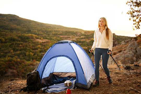 Woman camping in mountains enjoying nature during sunset
