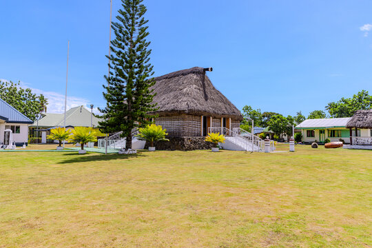 Traditional Fijian Bure house with thatched roof and tropical palm trees under a blue sky in Viseisei Village Nadi Viti Levu Fiji