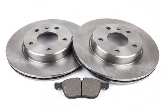New automotive brake discs and a brake pad isolated on a white background. Essential spare parts for car maintenance, repair, and safety.