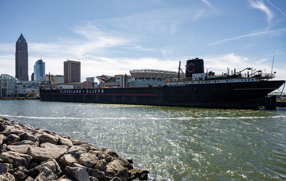 Cleveland, Ohio, United States - 08 October 2026: View of the historic William G. Mather steamship docked in the harbor with the Cleveland skyline and stadium in the background.