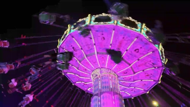 Buntes Kettenkarussell mit Menschen in voller Fahrt auf einem Volksfest