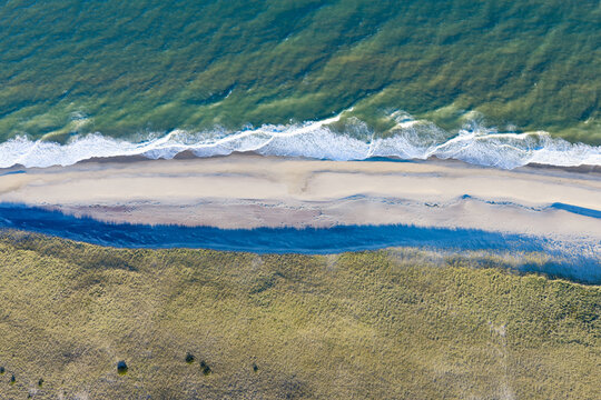 The cold waters of the Atlantic Ocean wash against Nauset Beach in Orleans, Massachusetts. This scenic area is on the outer part of Cape Cod is a popular vacation destination.