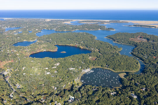 A bird's eye view of Orleans on outer Cape Cod shows kettle ponds and Pleasant Bay which is connected to the Atlantic Ocean. This scenic area is a popular east coast vacation destination.
