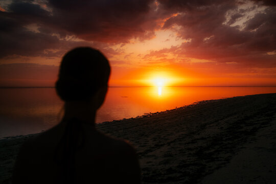 Kodi, Indonesia - 06 August 2026: View of a silhouette of a person watching a vibrant sunset over the calm ocean waters at ARYA Sumba.