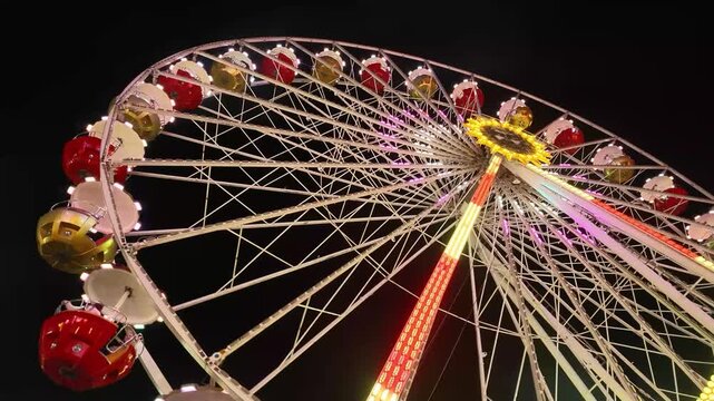 Farbenfroh beleuchtetes Riesenrad bei Nacht auf einem Volksfest