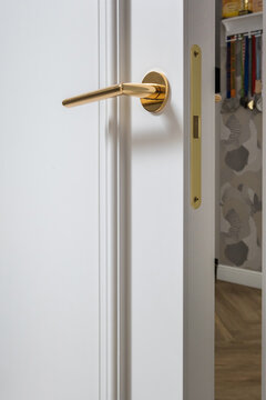 door handle on white wooden door in interior. Knob close-up elements. Door handle, fittings for interior design