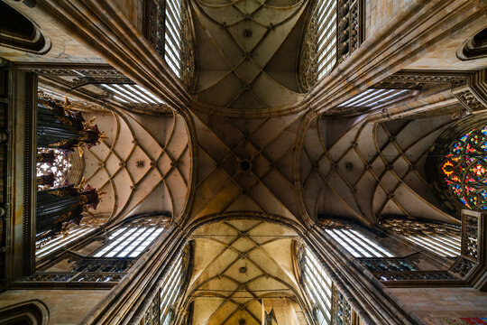 Prague, Czechia - 05 October 2026: View of the intricate Gothic vaulted ceiling and stained glass windows inside St. Vitus Cathedral.