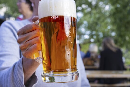 Woman (50-55) with a glass of beer in a beer garden, Prague, Bohemia, Czech Republic