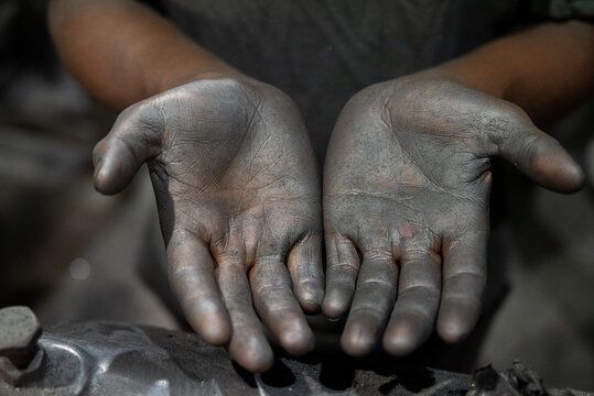 Dhaka, Dhaka Division, Bangladesh - 07 October 2026: View of a worker's hands covered in dark industrial soot and dust, highlighting the physical labor in an industrial setting.
