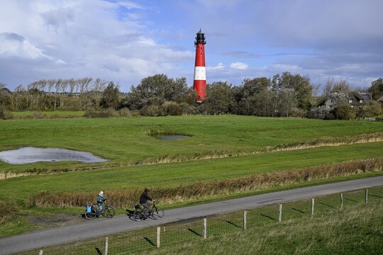 Cyclist in front of the lighthouse from 1906, island of Pellworm, Schleswig-Holstein Wadden Sea National Park, North Frisia, Germany