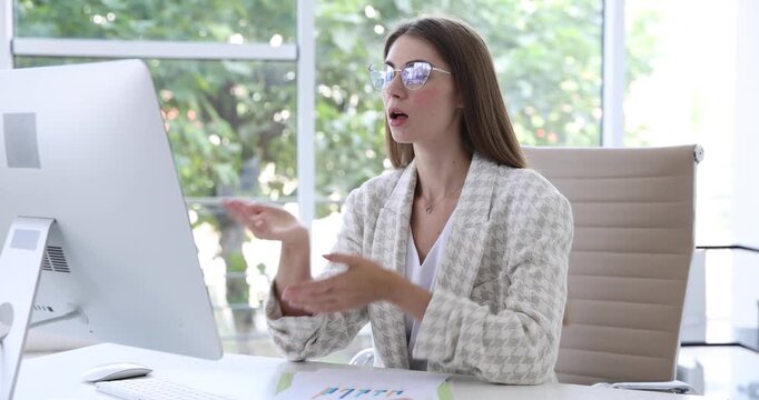 Human resources manager conducting online job interview via video chat on computer at table indoors