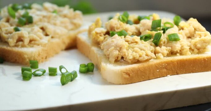 Sandwiches with cod liver and chopped green onion on board