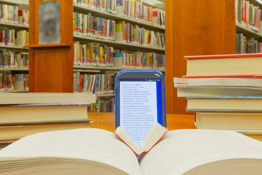 Smartphone Displaying Dictionary Definition Surrounded by Books in a Library