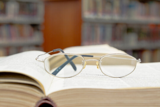 Eyeglasses Resting on an Open Book in a Library