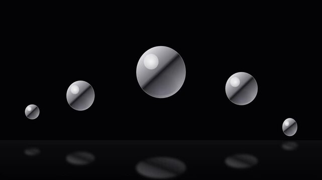 Five metallic spheres arranged in a graceful parabolic arc above a reflective dark surface create a striking visual harmony with dramatic highlights gleaming across their polished chrome