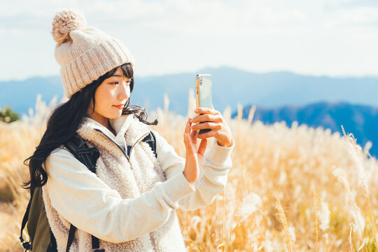 ススキ野原の写真を撮る女性