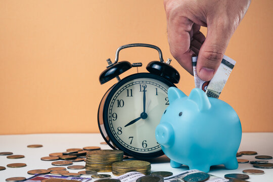 Piggy bank with an alarm clock and coins, saving and time, representing saving money, time management, long-term investment, and financial planning concept