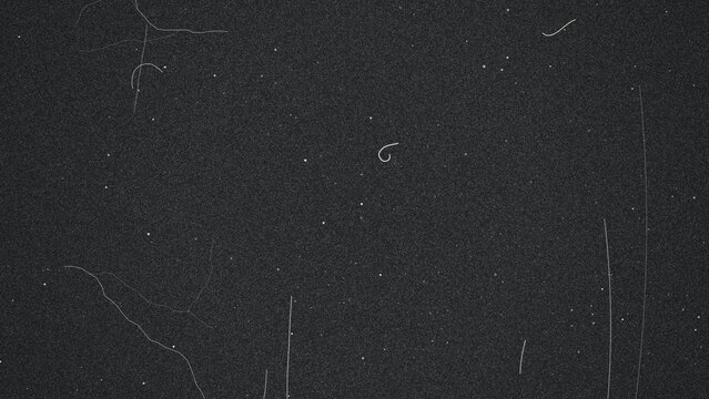 Black grunge film scratch texture with white specks and lines