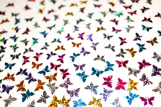 Colorful glitter butterfly sequins pattern texture on white background