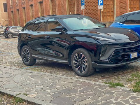 Black EVO 7 SUV parked on historic Italian cobblestone street, blending contemporary automotive design with classic urban architecture
