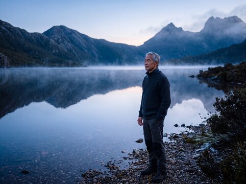 Senior Man Reflecting by Serene Alpine Lake During Quiet Dawn Blue Hour