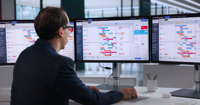 Receptionist Uses Computer To Register Visitor Badges