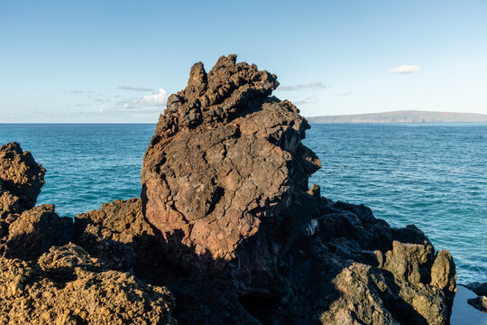 Scenic rock formation at the Pacific ocean coast that looks like a giant head along the Hoapili Trail at sunrise, Maui, Hawaii