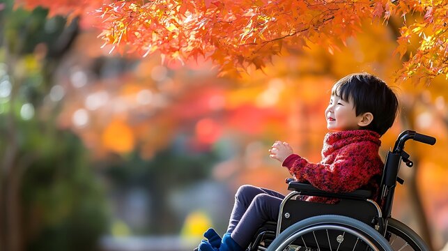 Disabled child sitting in modern wheelchair outdoors enjoying vibrant autumn foliage with bright sunlight illuminating seasonal park setting