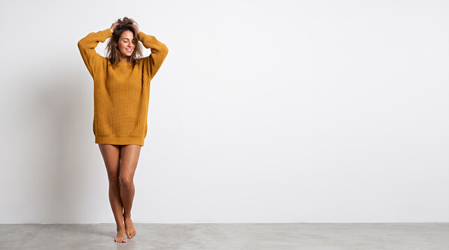 Woman in yellow knit sweater posing relaxed hands behind her head