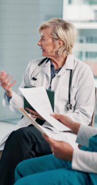 Doctor, woman and speaking in hospital with workshop, share knowledge or tablet for medical research. Healthcare worker, mature person and discussion in clinic with team, seminar or training meeting.