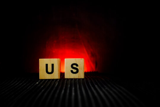 wooden letter tiles arranged on a dark surface with a warm red glowing background,