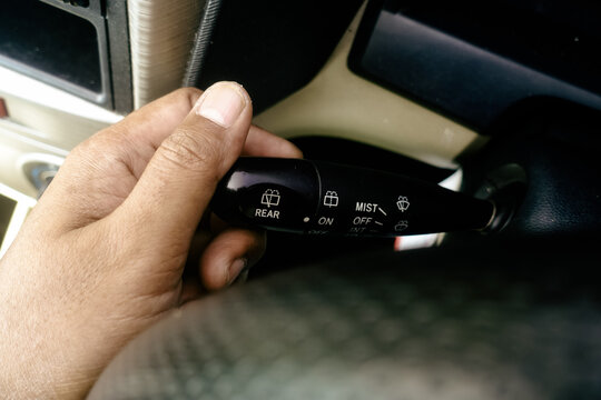 hand holding and operating the windshield wiper control
