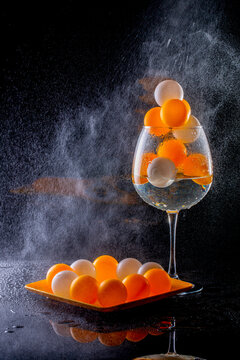 Glass with liquid and small spheres under water splashes