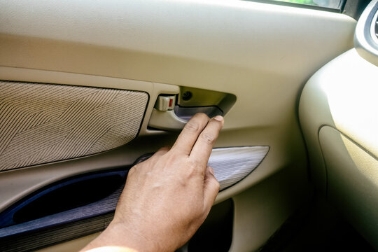hand pulling the inner door handle to open a car door from inside