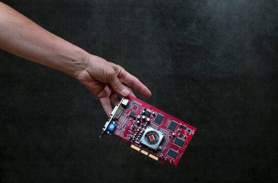 Man's hand is handing over a computer circuit board.