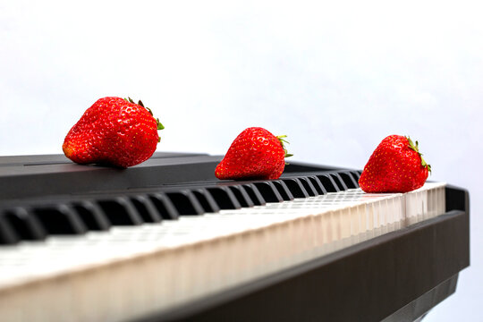 Ripe strawberries on piano keys