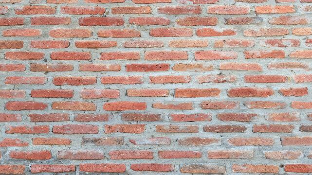 Full frame background texture of an old red brick wall with grey mortar