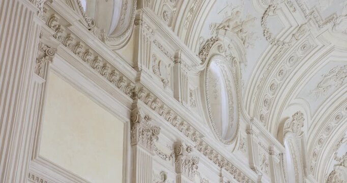 The view moves across ornate interior walls and a vaulted ceiling decorated with stucco figures, floral reliefs, fluted pilasters and oval windows.