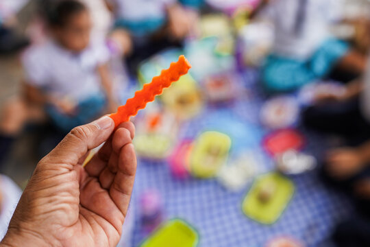Hand holding carrot during healthy school lunch picnic