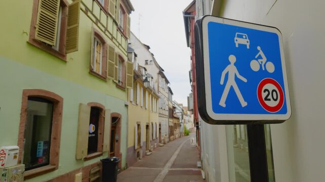 Traffic sign marks a 20 kmh shared street zone in Colmar, France, where pedestrians, cyclists and vehicles use a narrow historic residential lane