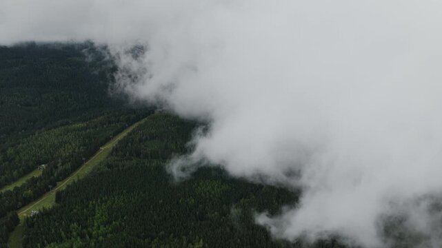 Thick Clouds Blanket The Mountain Slopes Around Sniezka In Karkonosze National Park, Southwestern Poland. Aerial Shot