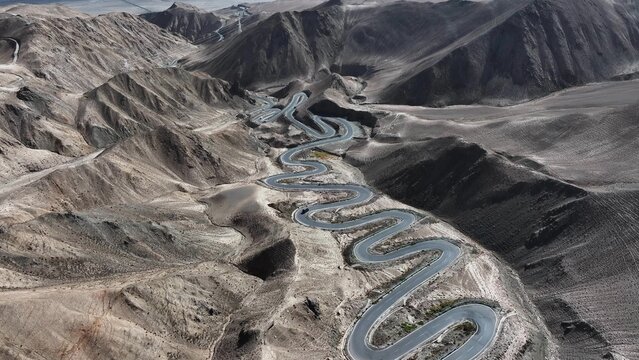 Aerial view of Panlong Ancient Road winding through Xinjiang desert mountains