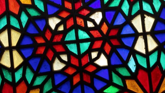 Vibrant stained glass windows with intricate Persian Orosi latticework and geometric patterns inside the historic Dowlatabad Garden pavilion in Yazd, Iran, showcasing traditional Iranian architecture.