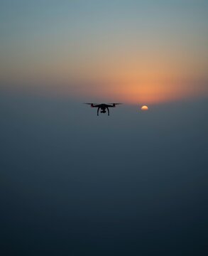 Drone Flying at Sunset Over Clouds for Technology and Innovation Background