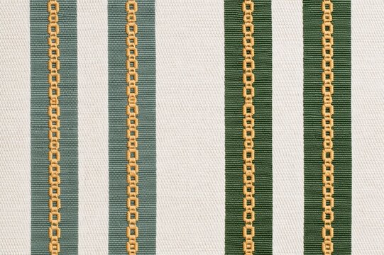 Green and white striped fabric with decorative gold stitching
