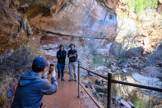 Tourists posing for photos at Lower Emerald Pool Trail. Zion National Park. Utah. USA.