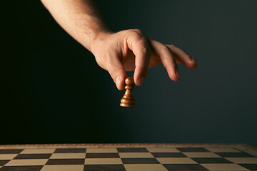 Close-up of a chess player's hand making a move. © Artvibe