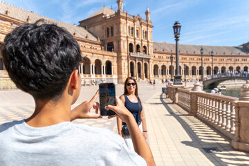 Young man photographing woman at plaza de españa seville © amfer75